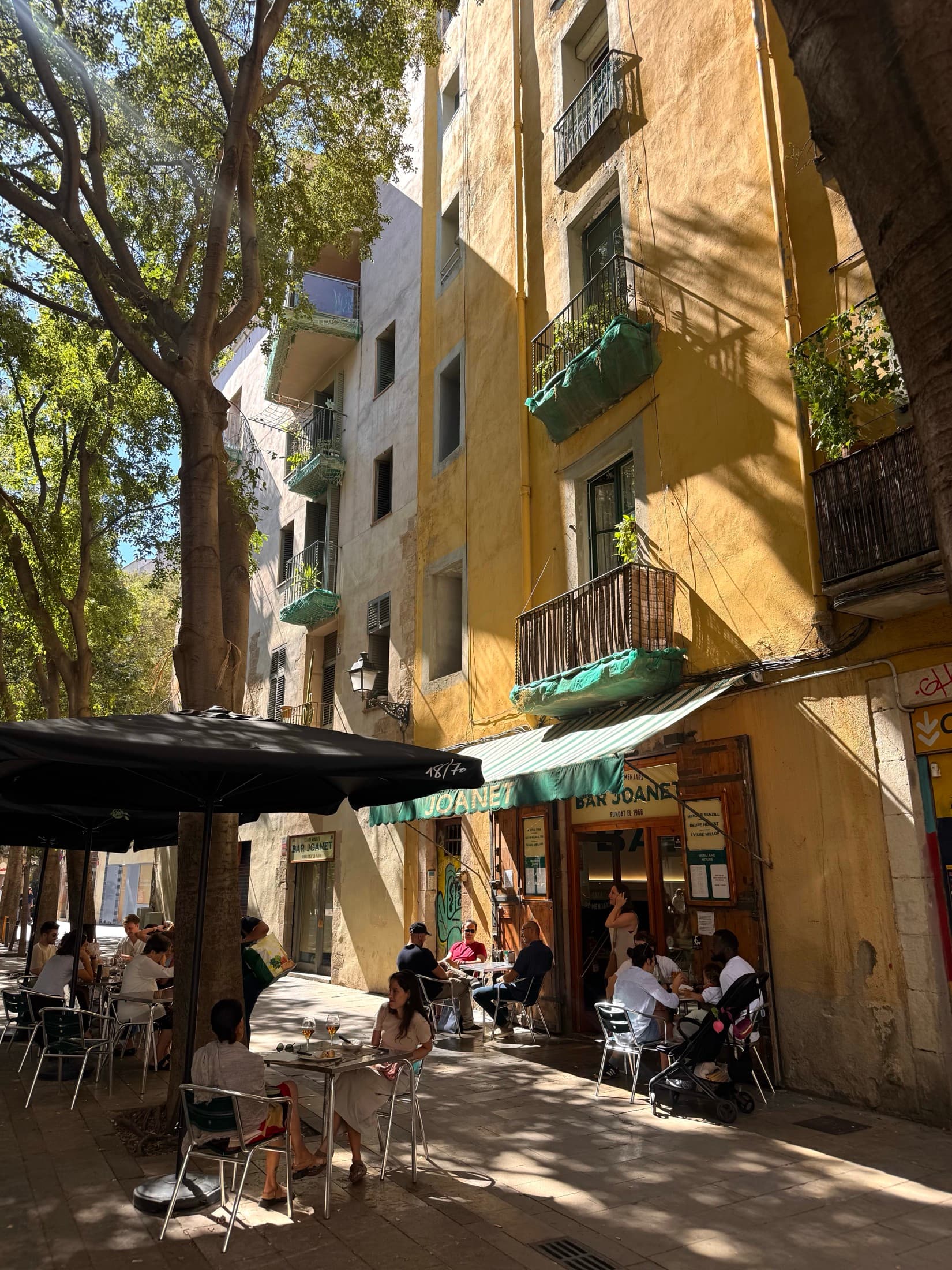 A lively Barcelona street with terraces and apartment balconies