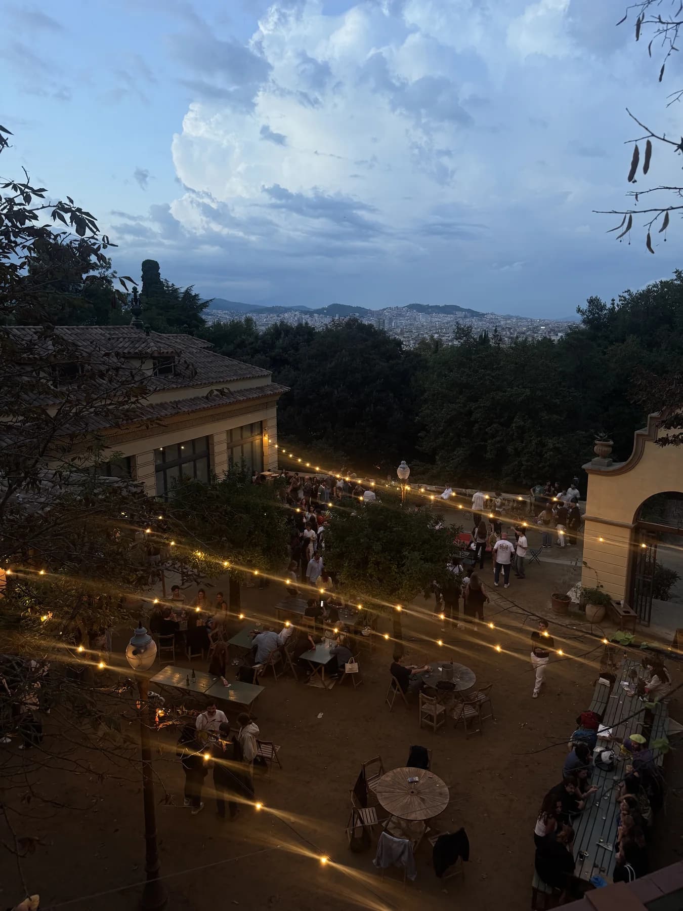 La Font del Gat outdoor restaurant at dusk with string lights and views over Barcelona